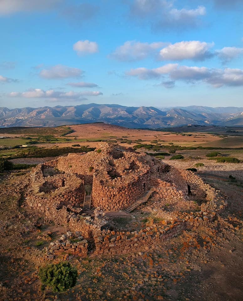 Vista aerea del Nuraghe Seruci al tramonto, con le montagne sullo sfondo