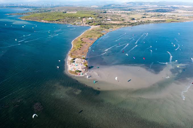 Decine di kitesurfer in acqua a Punta Trettu visti dall'alto